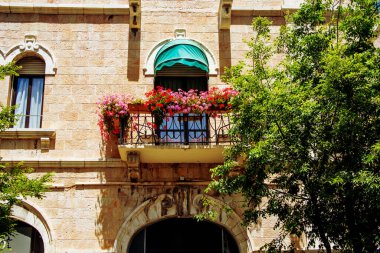 balcony decorated with pots with bright flowers on a sunny day, balcony floristic decoration