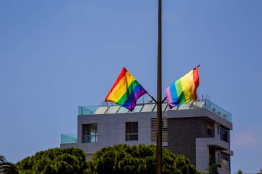 Direkte asılı gökkuşağı bayrakları ve mavi arka planda havada dalgalanan hava. LGBTQ topluluğu. Bayraklar - Altı çizgili versiyon