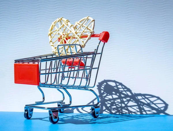赤の編組心青の背景に影とショッピングのためのミニショッピングトロリー 消費者の概念 ミニマリスト — ストック写真