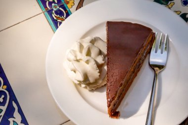 Kayısı ve krem şantili çikolatalı Sacher keki. Sachertorte, Franz Sacher tarafından 1832 yılında Viyana 'da Prens Metternich için icat edilmiş bir çikolatalı pasta.