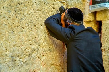 Kudüs, İsrail - 04 Temmuz 2021: Ortodoks Yahudi adam Yahudiliğin en kutsal yeri olan Batı Ağlama Duvarı 'nın yanında dua ediyor; Kudüs İsrail