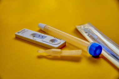 Hızlı ve basit bir şekilde COVID-19 antijeni evde 15 dakika içinde sonuç verir. Burun çubuğu kullanarak. sarı arkaplanda