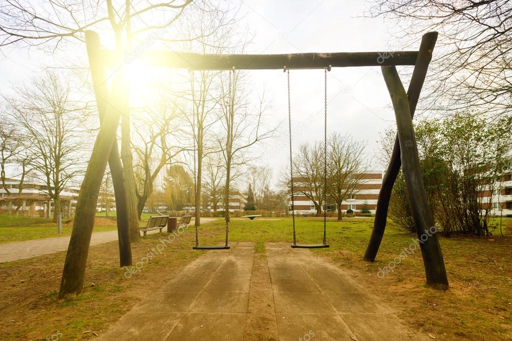 Swing on playground with sunset