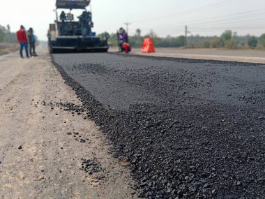 Asfaltlı yolların yapımında görüntü bulanıklaşıyor. Ağır makinelerle.