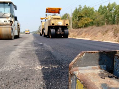 Asfaltlı yolların yapımında görüntü bulanıklaşıyor. Ağır makinelerle.