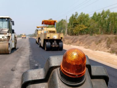 Asfaltlı yolların yapımında görüntü bulanıklaşıyor. Ağır makinelerle.