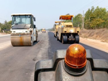 Asfaltlı yolların yapımında görüntü bulanıklaşıyor. Ağır makinelerle.