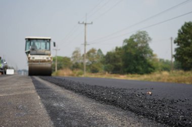 Görüntü asfalt yol yapımında bulanıklaşıyor. Ağır makinelerle.
