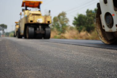 Görüntü asfalt yol yapımında bulanıklaşıyor. Ağır makinelerle.