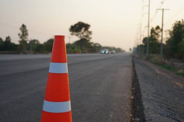 Kırmızı lastik koniler asfalt yola konur. Yoldaki güvenlik için