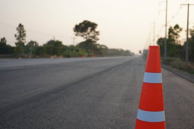 Kırmızı lastik koniler asfalt yola konur. Yoldaki güvenlik için