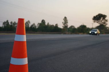 Kırmızı lastik koniler asfalt yola konur. Yoldaki güvenlik için