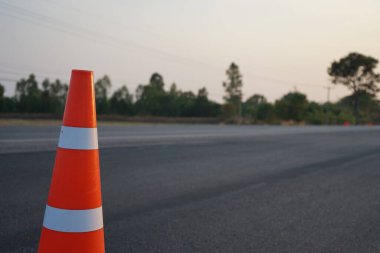 Kırmızı lastik koniler asfalt yola konur. Yoldaki güvenlik için