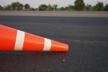 Kırmızı lastik koniler asfalt yola konur. Yoldaki güvenlik için