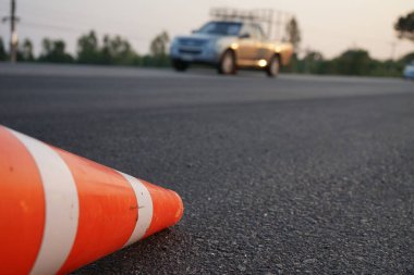 Kırmızı lastik koniler asfalt yola konur. Yoldaki güvenlik için