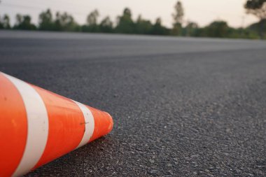 Kırmızı lastik koniler asfalt yola konur. Yoldaki güvenlik için