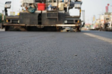 Görüntü asfalt yol yapımında bulanıklaşıyor. Ağır makinelerle.