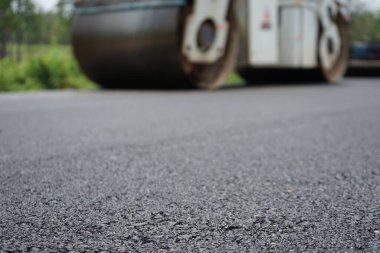Görüntü asfalt yol yapımında bulanıklaşıyor. Ağır makinelerle.