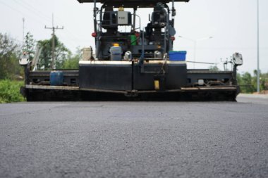 Görüntü asfalt yol yapımında bulanıklaşıyor. Ağır makinelerle.