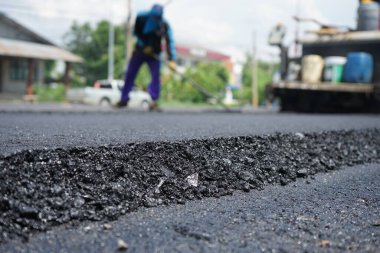 Asfaltlı yolların yapımında görüntü bulanıklaşıyor. Ağır makinelerle.