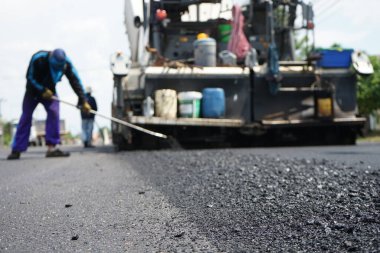 Asfaltlı yolların yapımında görüntü bulanıklaşıyor. Ağır makinelerle.