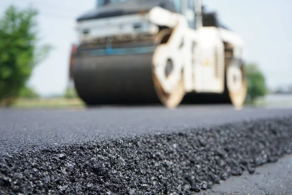 Görüntü asfalt yol yapımında bulanıklaşıyor. Ağır makinelerle.