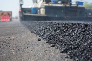 Görüntü asfalt yol yapımında bulanıklaşıyor. Ağır makinelerle.