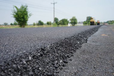 Görüntü asfalt yol yapımında bulanıklaşıyor. Ağır makinelerle.