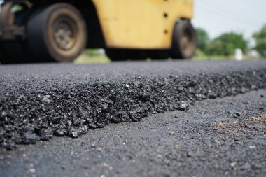 Görüntü asfalt yol yapımında bulanıklaşıyor. Ağır makinelerle.