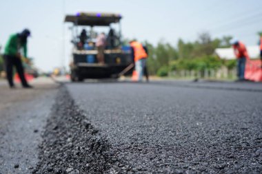 Görüntü asfalt yol yapımında bulanıklaşıyor. Ağır makinelerle.
