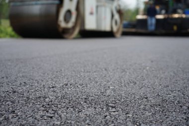 Görüntü asfalt yol yapımında bulanıklaşıyor. Ağır makinelerle.