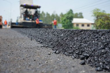 Görüntü asfalt yol yapımında bulanıklaşıyor. Ağır makinelerle.