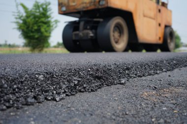 Görüntü asfalt yol yapımında bulanıklaşıyor. Ağır makinelerle.