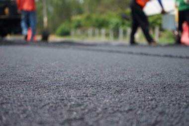 Görüntü asfalt yol yapımında bulanıklaşıyor. Ağır makinelerle.