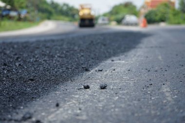 Görüntü asfalt yol yapımında bulanıklaşıyor. Ağır makinelerle.