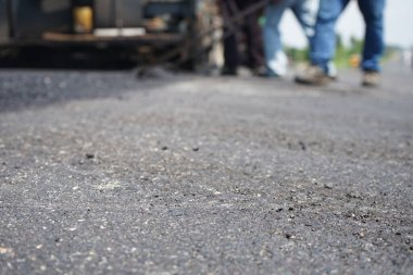Görüntü asfalt yol yapımında bulanıklaşıyor. Ağır makinelerle.