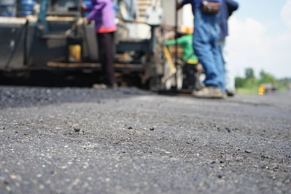 Görüntü asfalt yol yapımında bulanıklaşıyor. Ağır makinelerle.