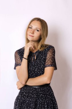 Beyaz arka planda koyu renk elbiseli güzel sarışın kadın.