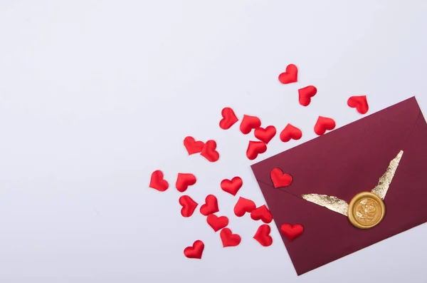 Envelop met liefdesbrief en rode hartvorm confetti. Valentijnsdag, bovenaanzicht — Stockfoto