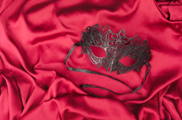 Venetiansk mask med svarta fjädrar på rött tyg — Stockfoto