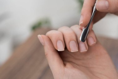 Kadın elleri evde manikür yapıyor.