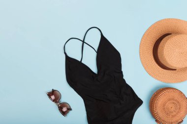 Güneş gözlüklü ve şapkalı siyah yüzme takımı.