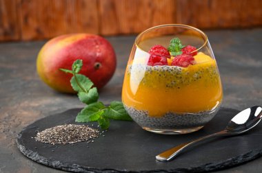 Hindistan cevizi sütü, mango püresi, mango ve ahududu ile ev yapımı Chia pudingi. Boşluğu kopyala
