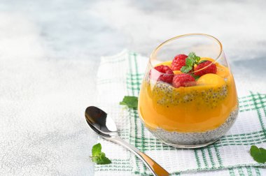 Hindistan cevizi sütü, mango püresi, mango ve ahududu ile ev yapımı Chia pudingi. Boşluğu kopyala