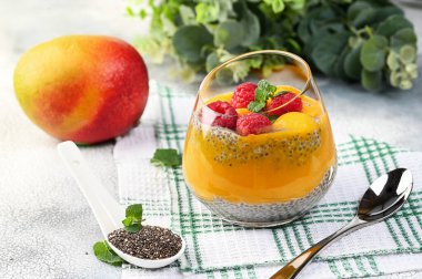 Hindistan cevizi sütü, mango püresi, mango ve ahududu ile ev yapımı Chia pudingi. Boşluğu kopyala