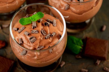 Nane aromalı vegan çikolatalı mus, bir kalıp çikolata ve koyu arkaplanda kakao çekirdeği. Boşluğu kopyala