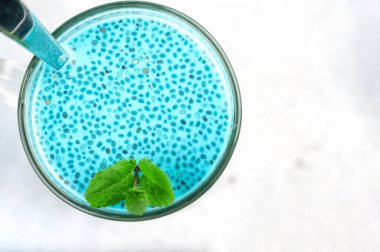 Kiraz mavisi çay chia tohumu pudingi taze naneli tatlı, hindistan cevizi sütü ve yabanmersinli hafif arka planda sağlıklı kahvaltı.