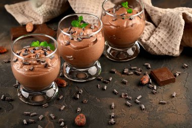 Nane aromalı vegan çikolatalı mus, bir kalıp çikolata ve koyu arkaplanda kakao çekirdeği. Boşluğu kopyala