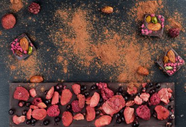 Kurutulmuş çilekli ev yapımı çikolata: ahududu, çilek ve fındık. Koyu arkaplan