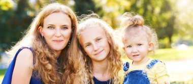 Anne ve küçük kızları. Mutlu aile fotoğrafı. Anne sarılması. Açık hava yaşam tarzı